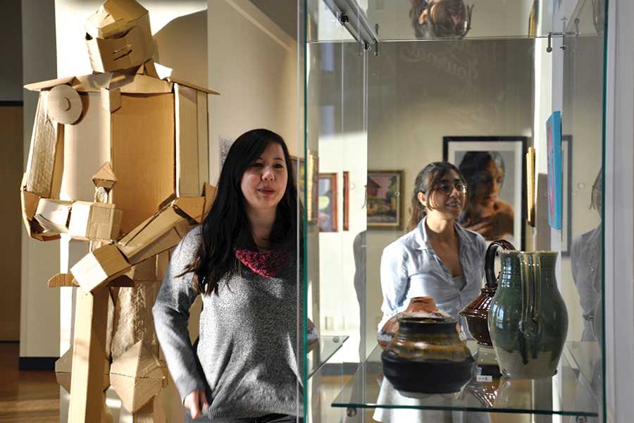 Yahara Journal graphic designer Kristina Karlen, left, and editor Paulina Kababie review the items on display in the student art show in the Truax Gallery.