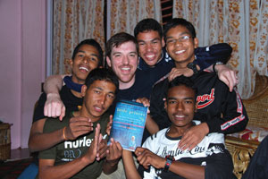 Next Generation Nepal founder and “Little Princes” author Conor Grennan with teens at NGNs Karnali House in Kathmandu, Nepal, holding an advance copy of Little Princes.