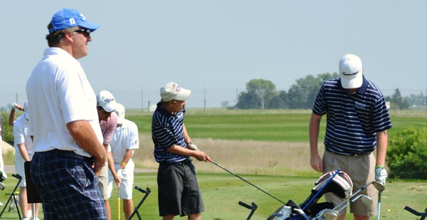 Madison College golf coach Pat Gorman watches two of his players warm up for a recent golf invitational in Janesville.