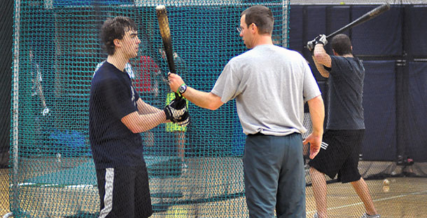 Madison College baseball coach Mike Davenport works with a hitter during a recent practice.