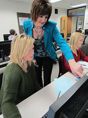 Madison College instrutor Kristin Uttech works with students in a marketing class.