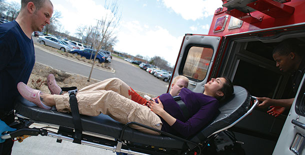 Randa Viet, portraying a woman who experienced a placenta abruption, is taken from the scene of a mock disaster in an ambulance.