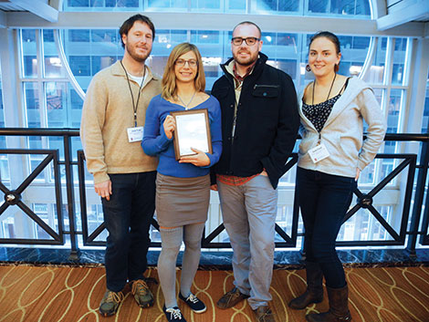 Clarion staff members, from left, Joe Pruski, Natalie Connors, Frederic Hewitt and Onawa Powell, show one of the awards the newspaper won at the Associated Collegiate Press National College Media Convention.