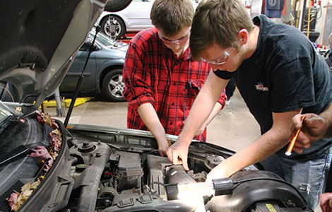 Students work on a car at the annual car care clinic.