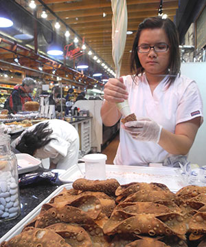 An employee fills crepes at one of the shops in the Reading Terminal Public Market in Philadelphia.