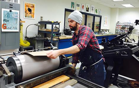 A student prepares a plate for inking in “the print lab.”