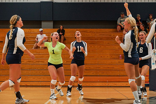 The team celebrates a point during the 2015 Volleyball Alumni match