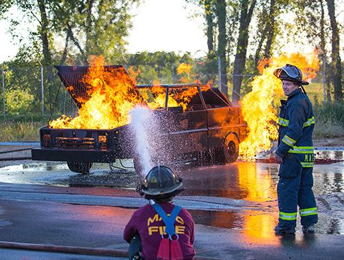 Two firefighters demonstrate how to put out a car fire