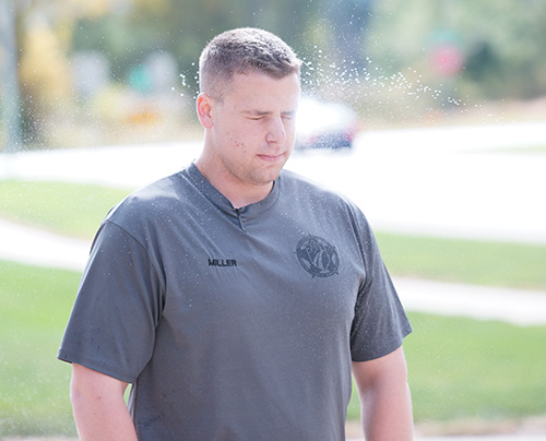 An officer is pepper sprayed during a training exercise outside the Protective Services building.
