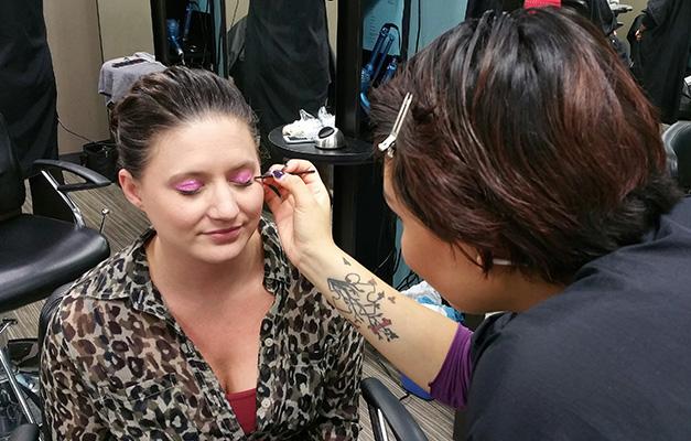 Rebecca Waraczynski getting her eye makeup done by Josaba Yerena Guzmán for breast cancer awareness.