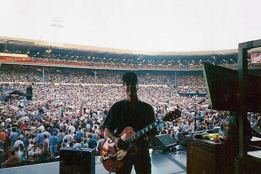 Todd Bowie tunes a guitar on stage before the start of an Eagles concert.