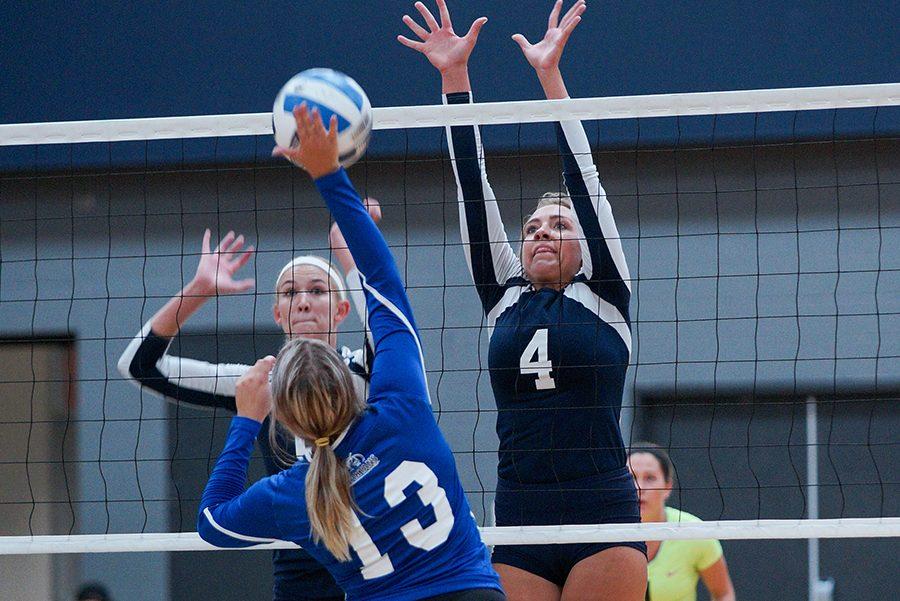 Madison College volleyball player Kiefer Zimmerman (4) leaps to block the ball during a 3-0 win over Elgin Community College on Aug. 25 as TeAnn Harms looks on.