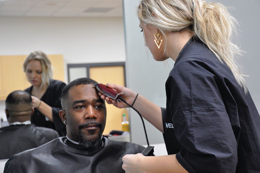 A barber-cosmetology student trims a customers hair in the new TruStyle Salon at the Madison College Truax campus.