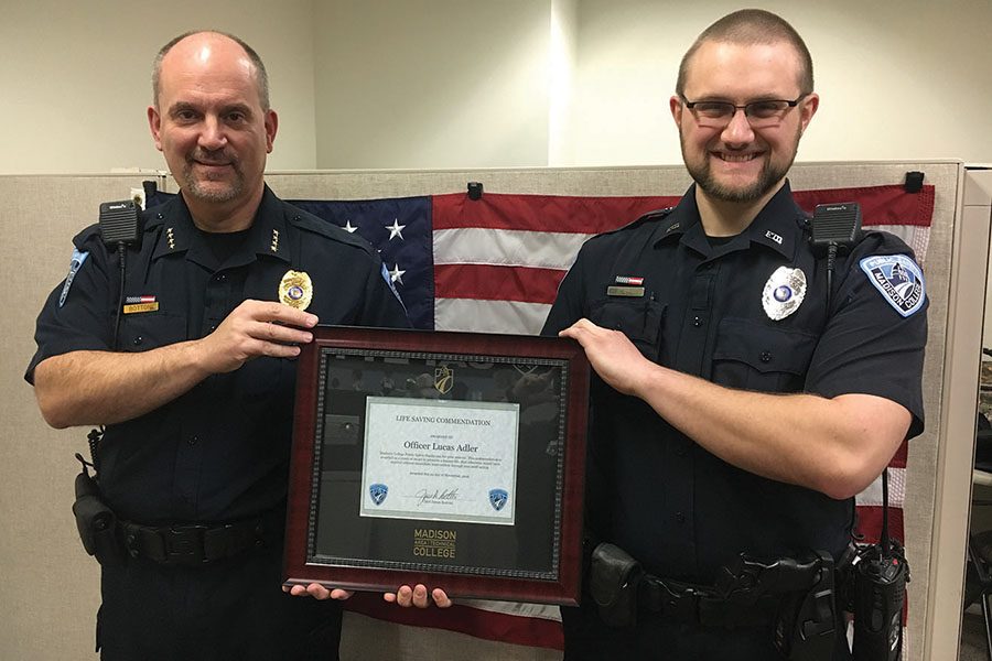 Public Safety Officer Luke Adler, right, receives an award from Chief Jim Bottoni.