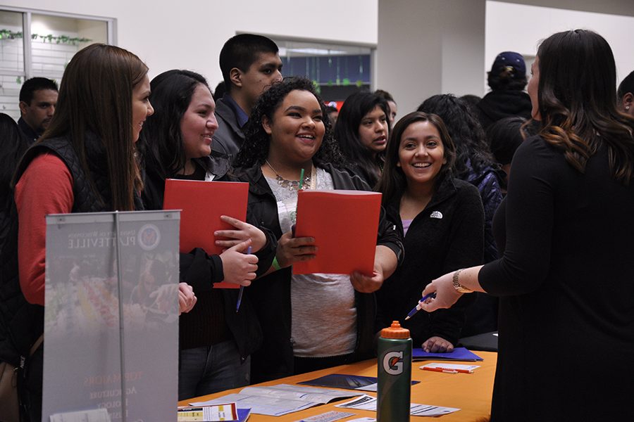 A group of high school students visits an information table during the Latino Youth Career and College Fair on March 17. The Asian Youth Career and College Fair will be held at Truax on April 7.