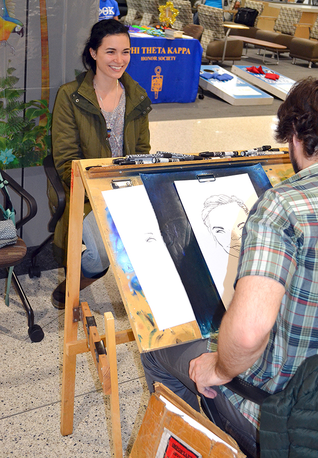 Caricature artist Theo Howard draws for a student at the grand opening ceremony.