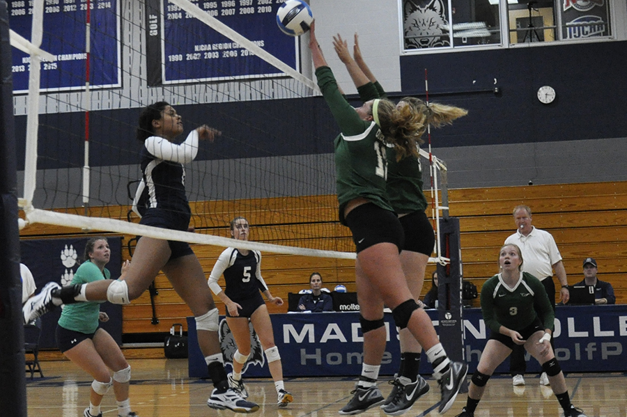 Madison College’s Lori Sanders, left, hits the ball through the block of two opponents during a recent match.