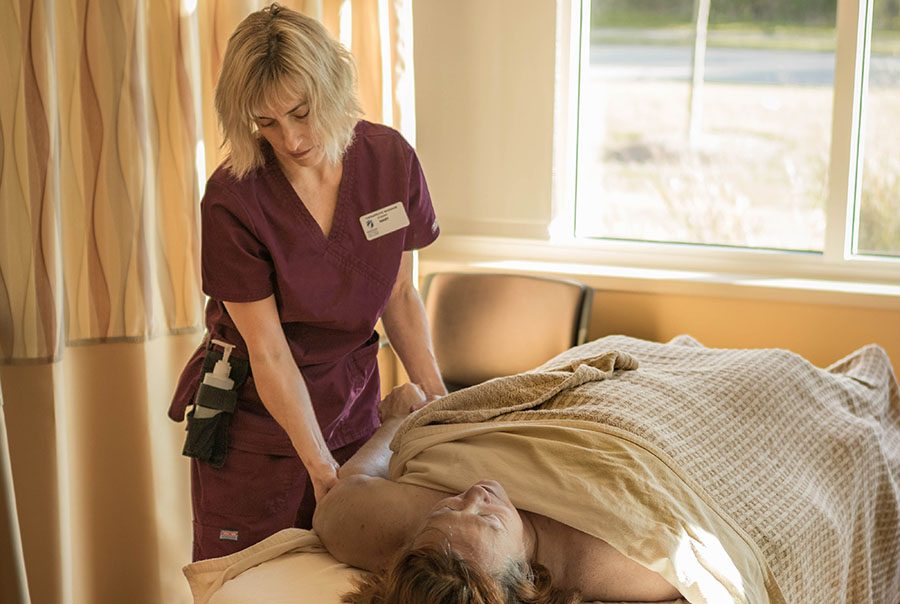 A student practices massage on a client at the clinic.