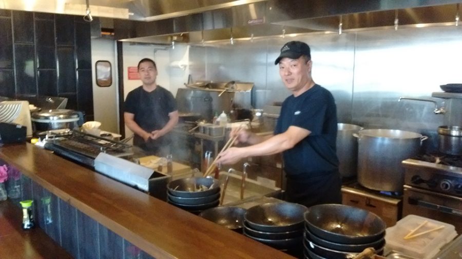 Workers prepare a meal at Ramen Station.