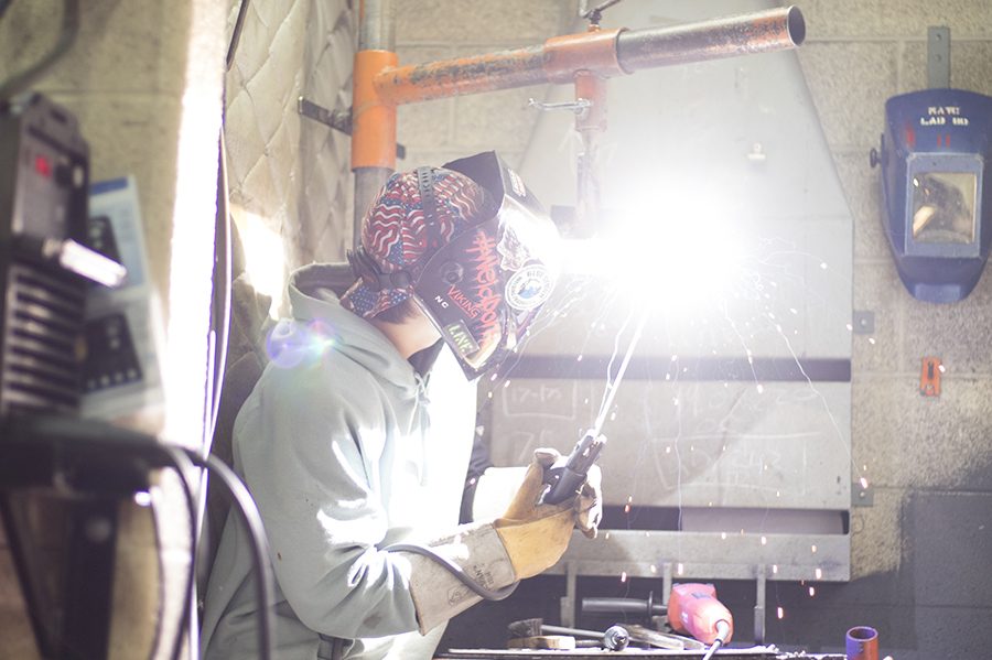 A student works in one of the welding bays at the Truax Campus.