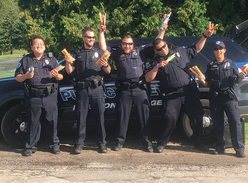 Public Safety officers warming students hearts with a cold popsicle