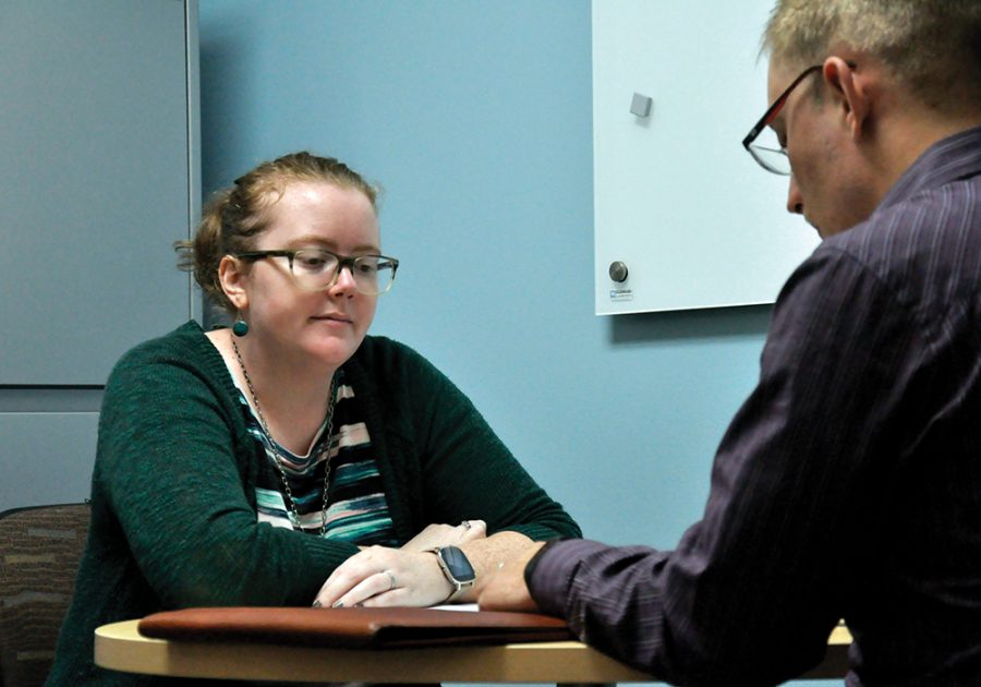 Ellie Rome visits with a student in her office