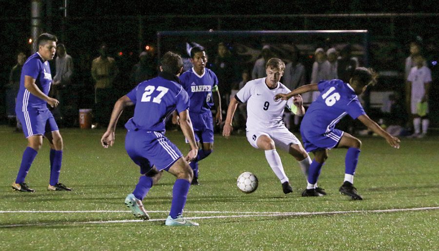 Madison College forward Shane Paterson fights off a trio of Harper College defenders