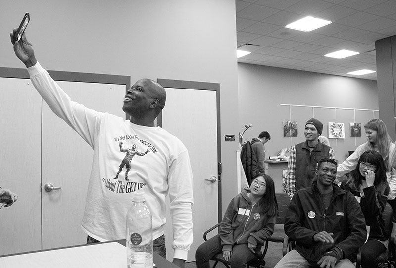 Motivational speaker Ian Humphrey takes a photograph of himself and members of the audience.