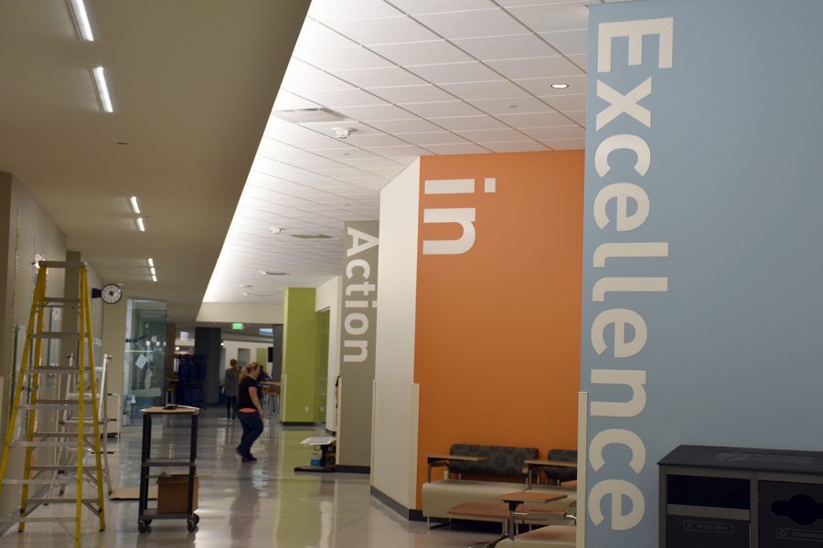 A worker installs the plaques and wording on the award wall.