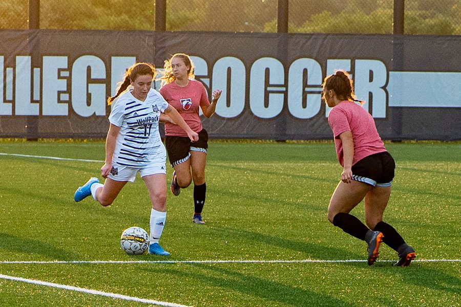 Madison+College+midfielder+Lydia+Webster+%2817%29+moves+the+ball+past+a+pair+of+defenders+during+her+teams+scrimmage+against+Edgewood+on+Aug.+22.