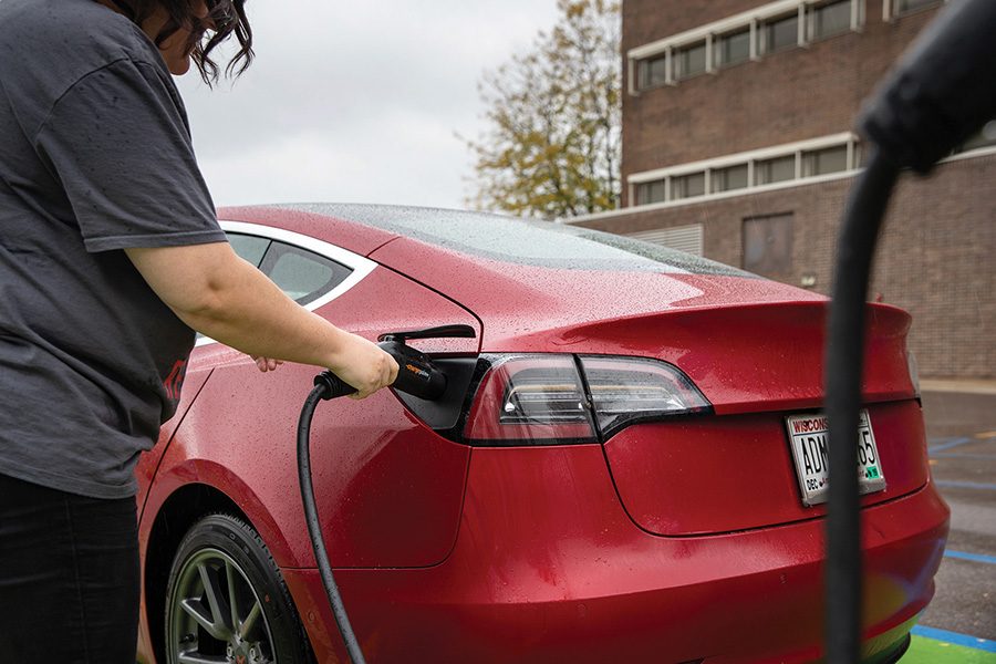 Madison College student Emily Dimond charges her car using one of the MGE charging stations at the college’s Truax Campus.