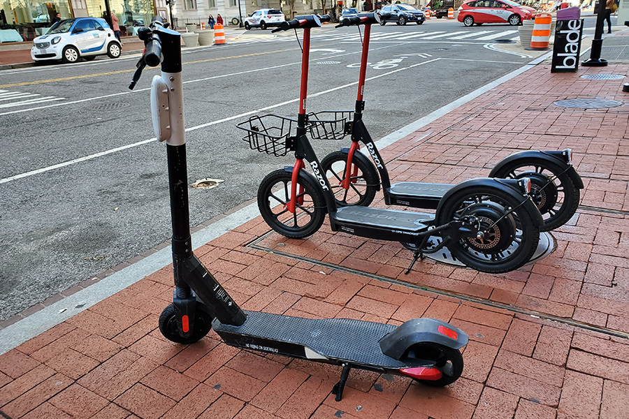 A+Bird+and+two+Razor+electric+scooters+rest+on+a+walkway+in+Washington%2C+D.C.%2C+waiting+for+riders.