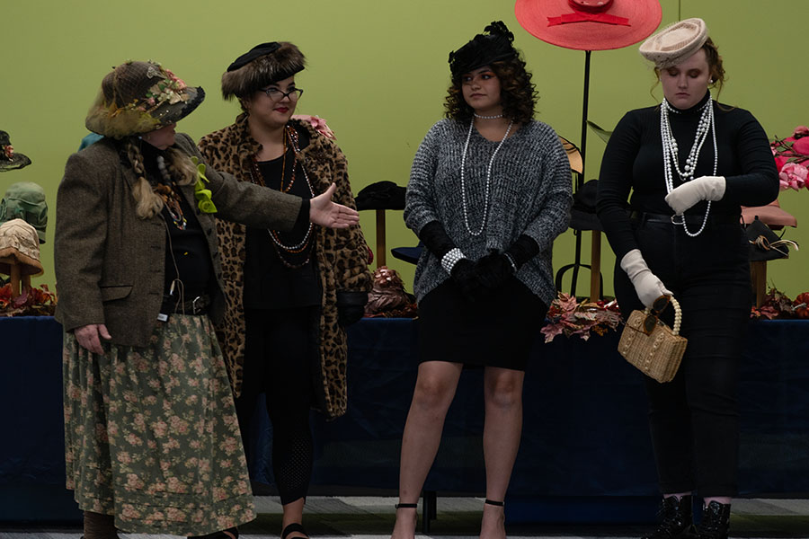 Gail Christensen (far left) talks about hats from the 1960’s. From left to right, Jena Yanagihashi, Ana Maria Moyer, and Kayla Sawyer model variations on the pillbox stye hat.