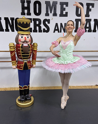 Sydney Bruce, a student at Madison College, poses in her costume next to a life size nutcracker.