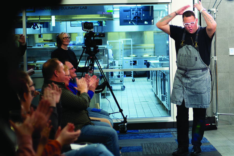 Chef Graham Elliot enthusiastically greets the crowd at the December Chef Series event at Madison College’s Truax Campus.