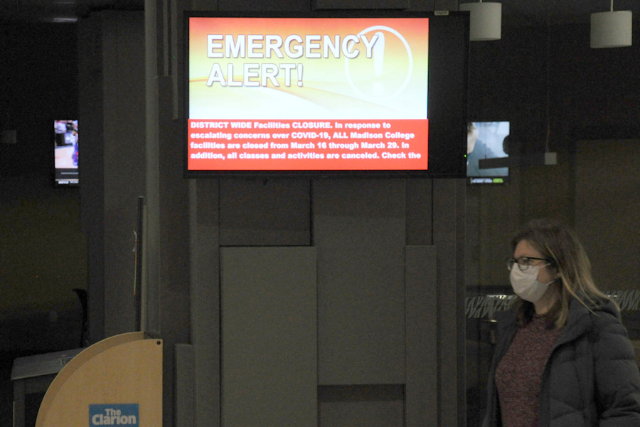 A WolfPack Alert notice on one of the campus monitors inside the Madison College main Truax building announces the initial campus closure, which has now been extended through May 15.