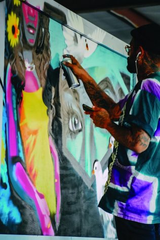 Madison artist Tony Catteruccia works on a mural he is painting as part of the Yahara Journal's Equity Project.