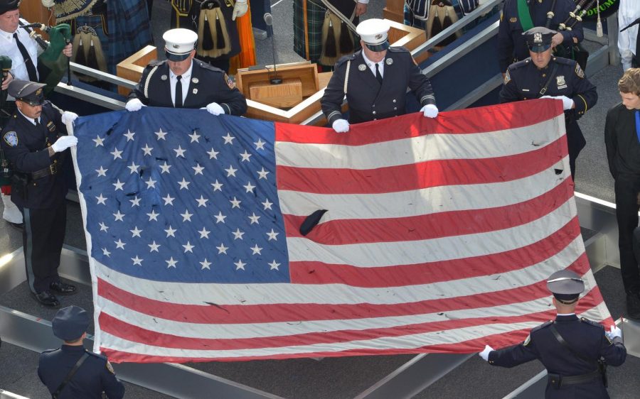 A U.S. flag recovered from the 9/11 attacks is displayed by New York City Police officers and firefighters during the ceremony marking the 10th anniversary of the terrorists attack in 2011.