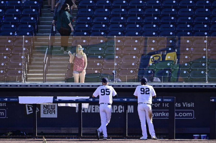 The New York Yankees’ Chris Gittens (92) and Trey Amburgey (95) talk with a fan through plexiglass due to the COVID 19 pandemic after a spring training game against the Toronto Blue Jays in Tampa, Florida, on Feb. 28.