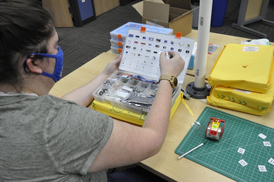 A student works to put together a STEM club kit.