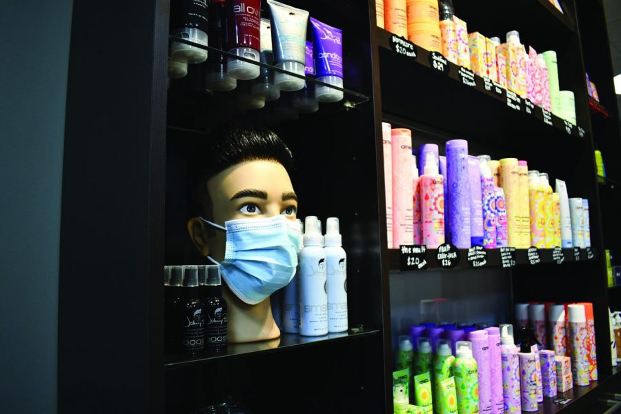 A mannequin head with a face mask on displayed at the Truax Salon.