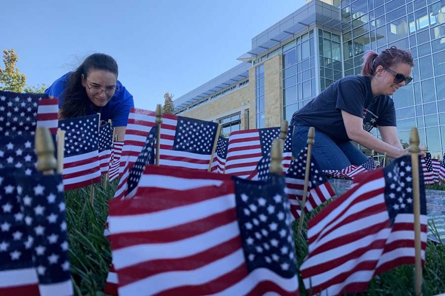 Phi+Theta+Kappa+members+set+up+a+flag+display+on+campus.