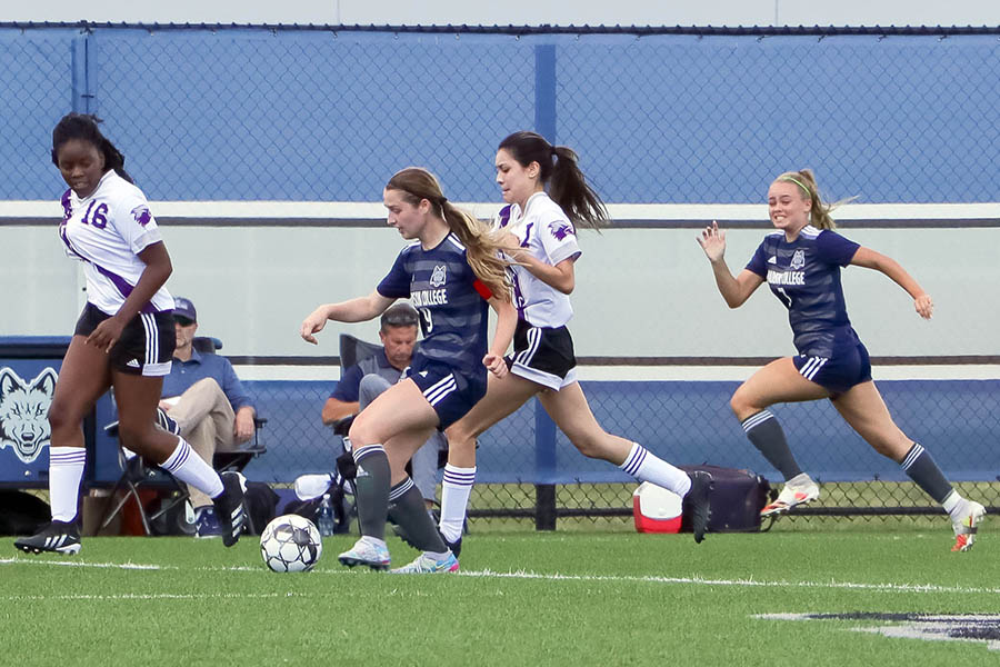 WolfPack womens soccer player Elizabeth Foye fights to get past defenders.