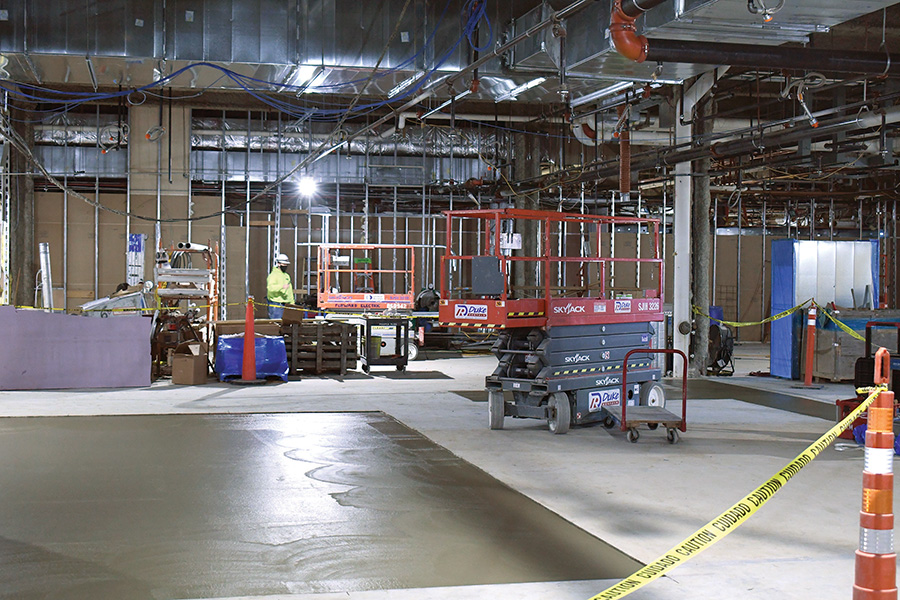 Workers move lifts around in the D-wing of the main Truax building.
