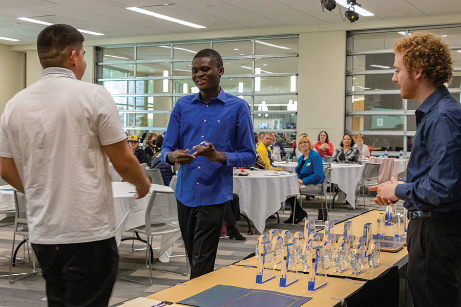 Ousmane Nikiema, center, and Ben Wiest, right, hand out awards at the annual Celebration of Student Success held on April 20 in Room D1630 at the Truax Campus.