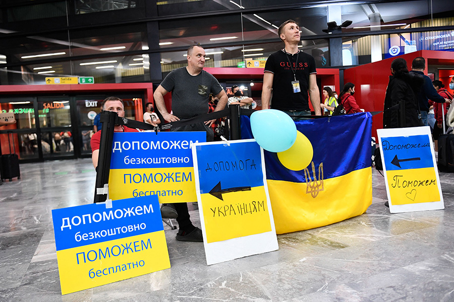 Volunteers with signs welcome Ukrainian refugees as they arrive at the Tijuana airport to help them on their journey to the United States after fleeing the war in Ukraine on April 8, 2022.