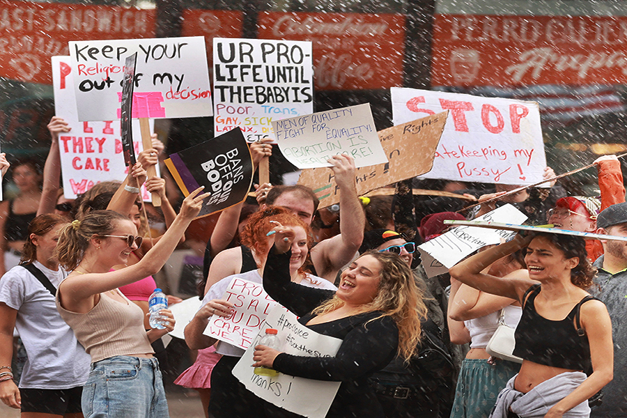 Demonstrators chant and hold signs in the rain during an abortion rights rally in downtown Orlando, Florida, on June 27, 2022. The rally is in response to the U.S. Supreme Court overturning Roe v. Wade.