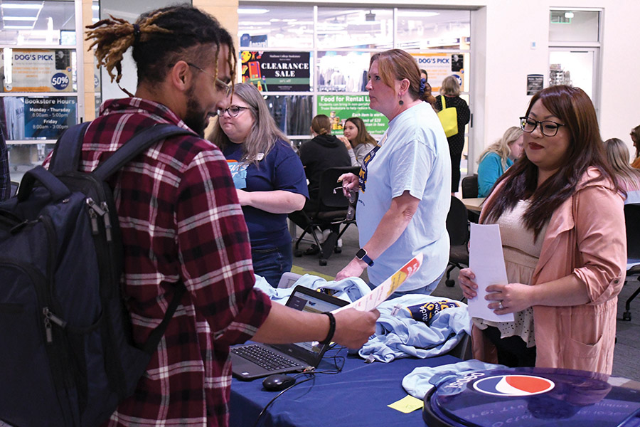 Staff members talk to students about the new student website.