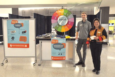 Madison College staff Zong Her and Gage Matthews encourage students to complete the Student Satisfaction Inventory survey in the Truax Cafeteria on Nov. 7.