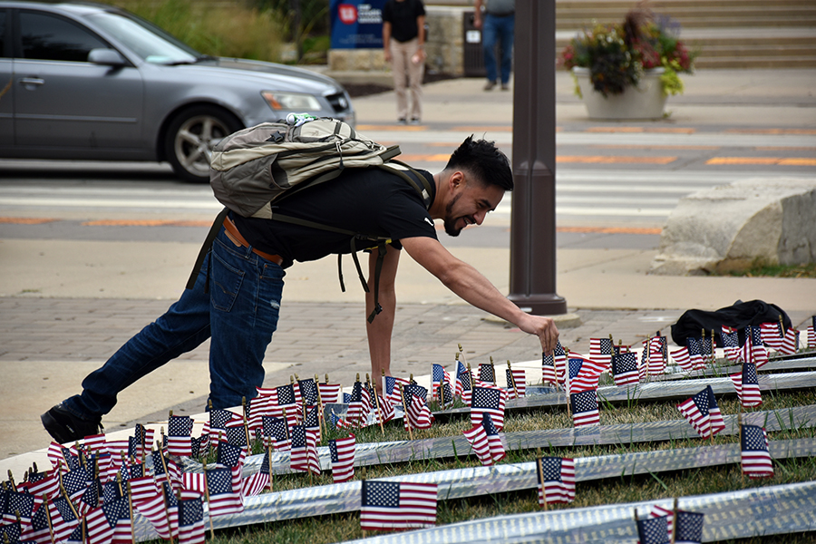 A+student+places+a+flag+on+Lussier+Student+Plaza+on+Sept.+7+in+memory+of+the+victims+of+9%2F11.